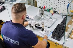 Ein KOMSA Mitarbeiter arbeitet an der Reparatur eines Smartphones