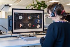 Eine KOMSA Mitarbeiterin mit einem Headset sitzt am PC und nimmt am Meeting teil