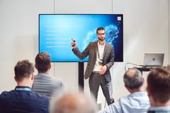 KOMSA Mitarbeiter steht am Flatscreen und hält Präsentation