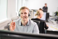 Mitarbeiter der KOMSA trägt ein Headset und berät einen Kunden telefonisch
