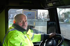 Ein Produktionsmitarbeiter in Warnweste in der Produktionshalle bedient die Montagestation