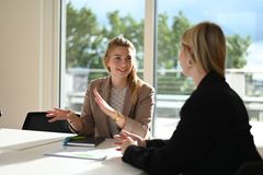 Ein Produktionsmitarbeiterin in der Produktionshalle hält ein Karosserieteil mit Arbeitshandschuhen in der Hand.