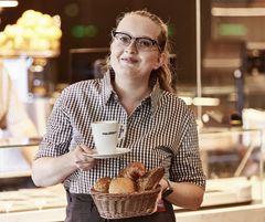 Mitarbeiterin serviert Frühstück