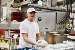 Mitarbeiter MALZERS legt Brotlaibe in die Kastenform