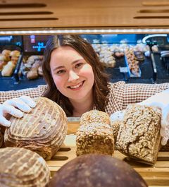 Auszubildende schaut durch das Brotregal