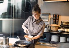 Filialmitarbeiterin bereitet Rührei zu