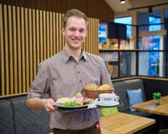 Auszubildender serviert Frühstück