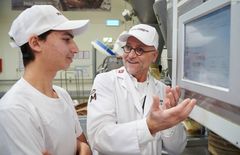 Ausbilder erklärt einem Praktikanten in der Backstube einen Bildschirminhalt