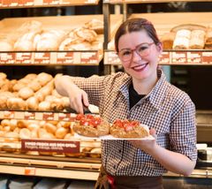 Verkäuferin bietet Erdbeerplunder an