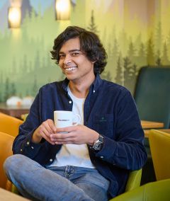 Auszubildender mit Kaffeetasse im Pausenraum