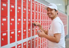 Azubi mit Schlüssel vor roten Spinden 