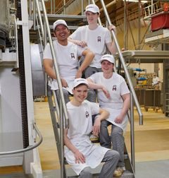 Bäcker Azubis sitzen auf auf einer Treppe in der Backstube