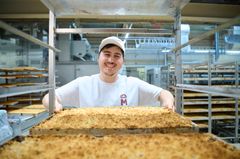 Auszubildender einer Bäckerei mit Kuchen 