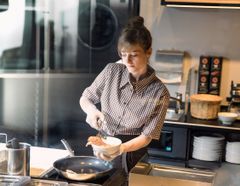 Frau bereitet Rührei in einer Bäckerei zu