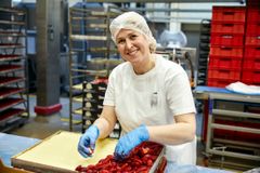 Konditorin belegt Erdbeerkuchen