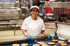 Produktionsmitarbeiterin einer Bäckerei am Fließband 