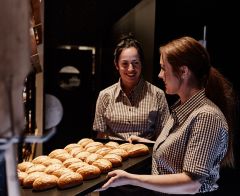 Verkäuferinnen backen frische Brötchen.