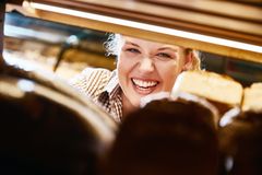 Verkäuferin schaut durch das Brotregal