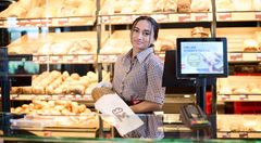 Auszubildende packt ein Brot ein