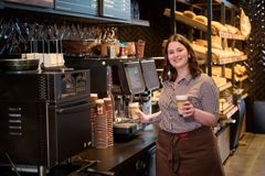 Auszubildende steht an der Kaffeemaschine