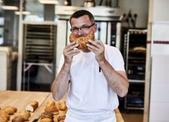 Portait Burkhardt Lücke MALZERS mit Croissant vor dem Mund