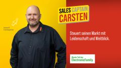 Linke Bildhälfte: Freundlich in die Kamera schauender Franchisepartner vor gelbem Hintergrund. Rechte Bildhälfte (Schriftzüge): Sales Captain Carsten - Steuert seinen Markt mit Leidenschaft und Weitblick.