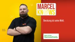 Linke Bildhälfte: Mitarbeiter im schwarzen MediaMarkt-Polohemd vor gelbem Hintergrund. Rechte Bildhälfte (Schriftzüge): Marcel Knows – Beratung ist seine Welt.