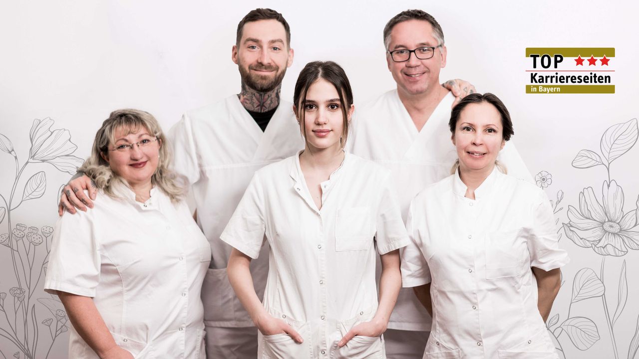 Fünf Menschen in weißer Arbeitskleidung stehen nebeneinander, blicken lächelnd in die Kamera und bilden ein Team. In weißer Schrift steht mittig #getinwolfed.