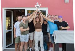 Mitarbeiter:innen halten Pokal in die Höhe