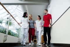 Interdisziplinäres Team läuft gemeinsam den Gang entlang im Reha-Zentrum.