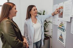 Zwei Mitarbeiter:innen an einer Pinnwand