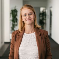 Eine junge Frau mit weißer Bluse und braunem Blazer präsentiert sich als Recruiterin der ProPotsdam GmbH.