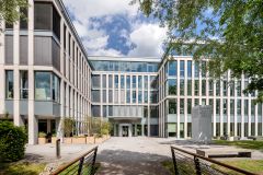 Modernes Bürogebäude der ProPotsdam in der Pappelallee 4 in Potsdam mit Brücke und Bäumen im Vordergrund. 