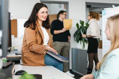 Austausch zwischen zwei Mitarbeiterinnen an einem Schreibtisch