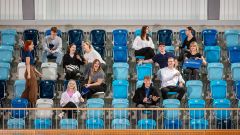 fröhliche, junge Menschen auf einer Tribüne
