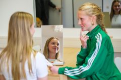 Eine Schülerin zeigt einer Kommilitonin eine Sprechübung mit Gestik vor.