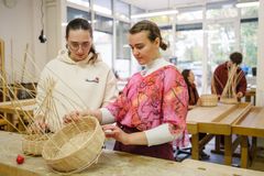 Zwei Frauen flechten in einer Werkstatt Körbe.