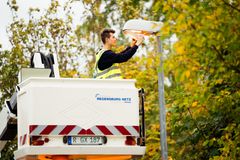 Ein Monteur steht auf einem Regensburg Netz Kran und arbeitet an einer Straßenlaterne