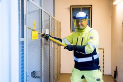Ein Mann mit Sicherheitsuniform arbeitet an einer Hochspannungsleitung