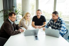 Mitarbeiter der REWAG sitzen gemeinsam an einem Tisch, vor einem Laptop und besprechen etwas