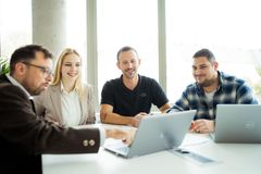 Insgesamt vier Elektroningenieure der REWAG (drei Männer und eine Frau) sitzen gemeinsam an einem Tisch, vor einem Laptop und besprechen etwas.