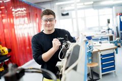 Azubi im Bereich Energie- und Gebäudetechnik arbeitet an einer elektrischen Maschine, um deren Funktionalität sicherzustellen – ein wichtiger Schritt in seiner Ausbildung