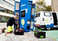 Eine Elektrofachkraft arbeitet an einer REWAG Ladestation vor der Firma 