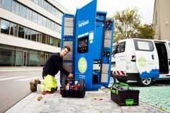 Eine Elektrofachkraft der Regensburg Netz GmbH arbeitet an einer REWAG-Ladestation vor dem Verwaltungsgebäude der REWAG.