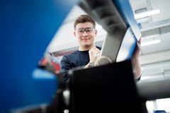 In der Werkstatt arbeitet ein Mechatroniker-Azubi konzentriert an einer technischen Maschine – Verbindung von Theorie und Praxis im Ausbildungsalltag.