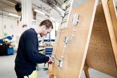 Junger Azubi in der Ausbildung zum Elektroniker für Energie- und Gebäudetechnik übt das fachgerechte Verbinden und Verlegen von Kabeln.
