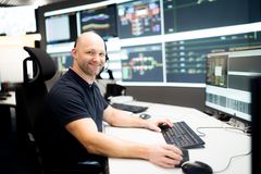 Dieses Bild zeigt einen Mann vor mehreren Monitoren bei seiner Arbeit