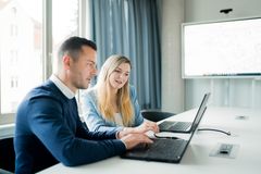 Dieses Bild zeigt einen Mann und eine Frau, die konzentriert an ihrem Laptop arbeiten