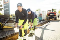 Zwei Azubis verlegen Leitungen in der Stadt. 