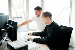 Ein Kollege von der IT erklärt dem Azubis Daten- & Prozessanalyse. 